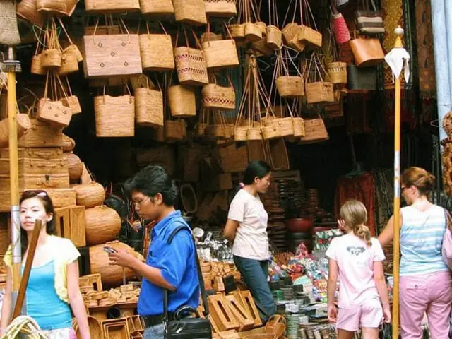 Visitors browsing a woodcarving workshop's craft stall