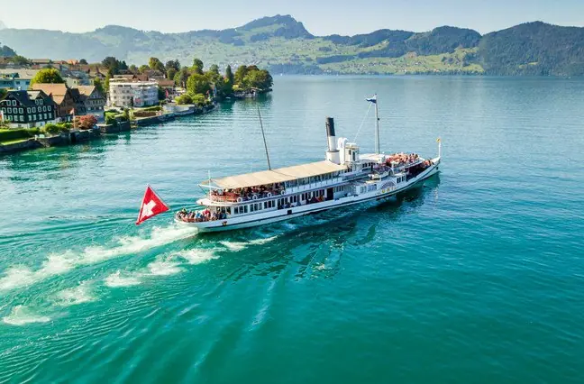 A lake steamer passing an alpine village in Switzerland
